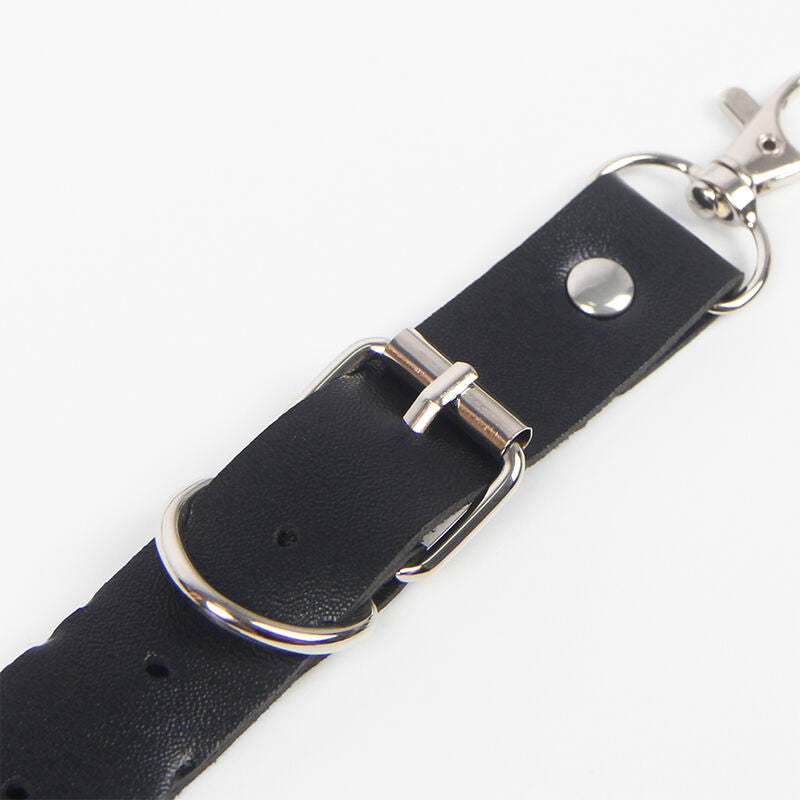 Detalhe do Cinto e Arnês de Liga SUBBLIME com anéis e corrente em couro preto.